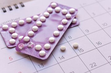 Antibabypille in lila Blisterpackung auf einem Kalender, verbunden mit potenziellen Nebenwirkungen wie Vitamin- und Mineralstoffmangel.